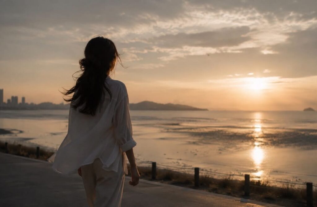 女子獨自走在晨曦海邊,象徵不再需要他人證明,自己走向釋懷